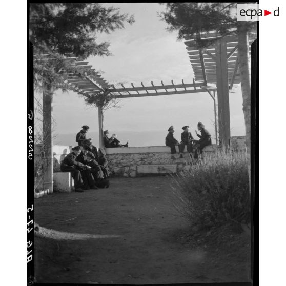 Des élèves sont réunis sous une tonnelle, lisent ou discutent.