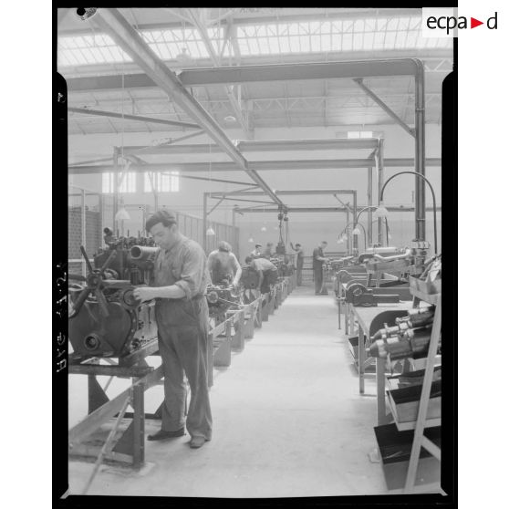 Des ouvriers de montage en construction automobile assemblent des pièces et composants, dans un atelier des usines Berliet, à Alger.