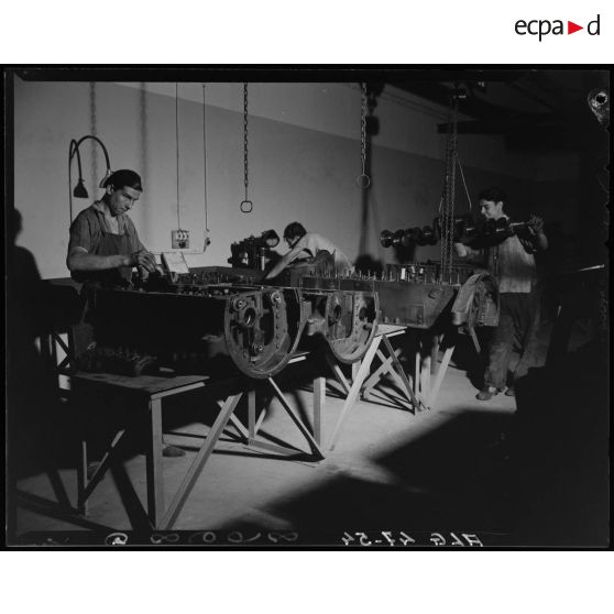 Des ouvriers de montage en construction automobile assemblent des pièces et composants, dans un atelier des usines Berliet, à Alger.