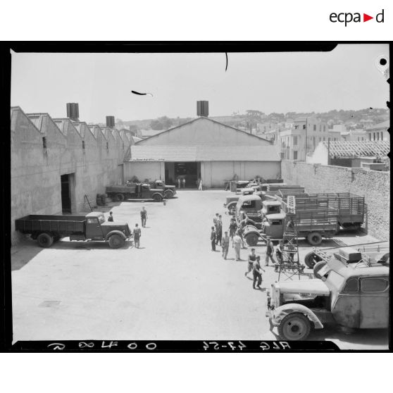 Plan en plongée d'une cour de stationnement de véhicules, dans l'enceinte des ateliers Berliet, à Alger.