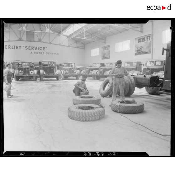 Des garagistes réparent des pneus, dans un garage des usines Berliet, à Alger.