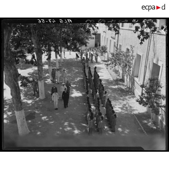 Plan en plongée d'autorités militaires et civiles qui passent en revue les enfants de troupe.