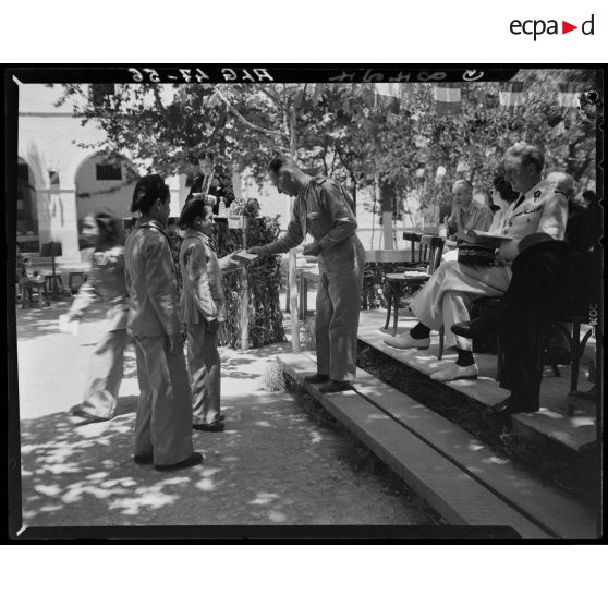 Une autorité militaire remet un prix à un élève de l'Ecole préparatoire nord-africaine (EMPNA) de Miliana, sous le regard d'autorités civiles et militaires.
