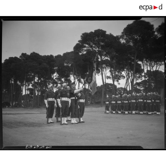 Garde au drapeau d'une unité de tirailleurs, sous le regard de jeunes recrues de la classe 46/2.