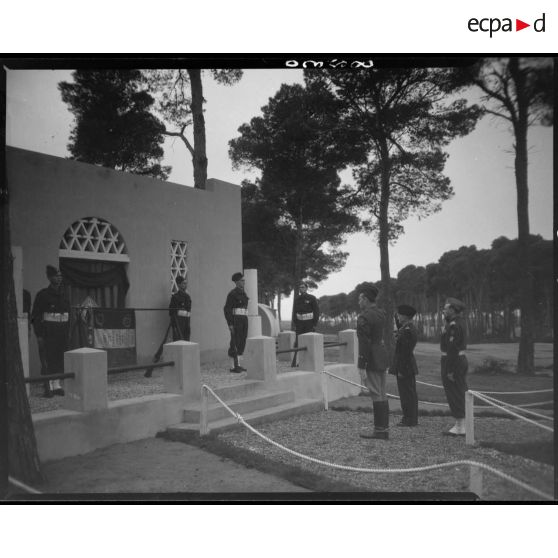 Le général Schlesser, accompagné de deux autorités militaires, salue le drapeau du 1er régiment de tirailleurs sénégalais (RTS).