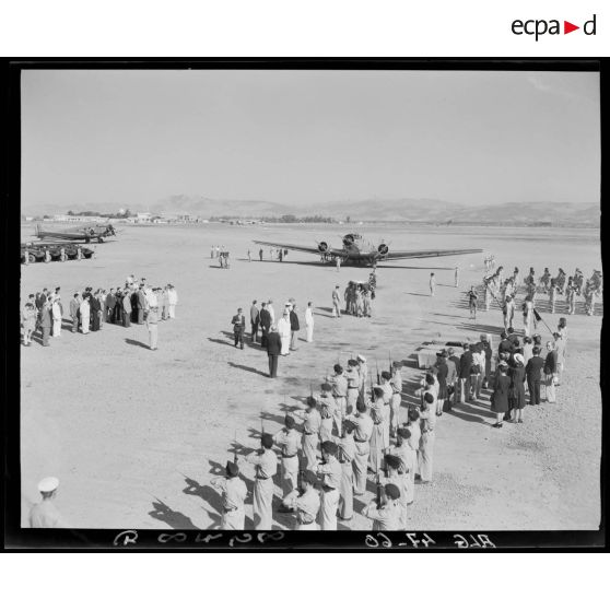 Vue en plongée du rapatriement des premiers corps tombés au champ d'honneur, sur un aérodrome, sous le regard d'autorités civiles et militaires, à Alger.