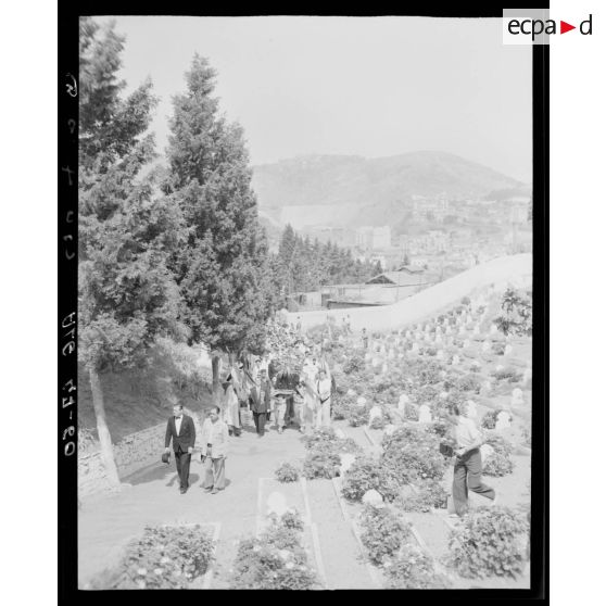 Des porteurs transportent les cercueils des premiers corps tombés au champ d'honneur, dans un cimetière, à Alger.