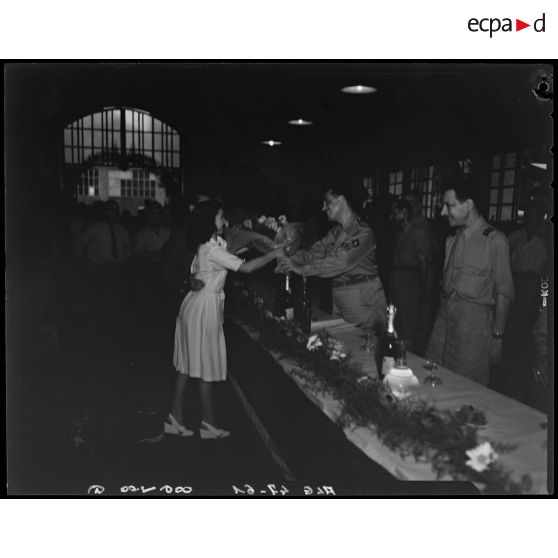 Une jeune fille remet un bouquet de fleurs au colonel Enjalabert, lors de la réception organisée pour son départ.