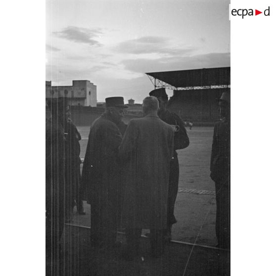 Le gouverneur général de l'Algérie Yves Chataigneau, accompagné du général Duché, remet une coupe à un vainqueur des championnats militaires sportifs.