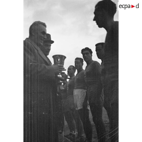 Le gouverneur général de l'Algérie Yves Chataigneau, accompagné du général Duché, remet une coupe à un vainqueur des championnats militaires sportifs.