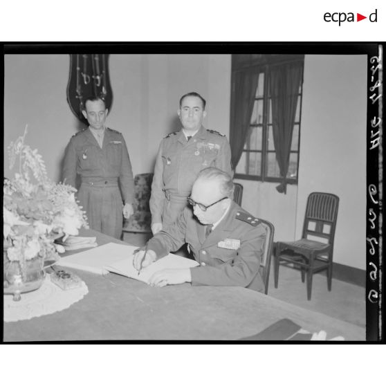 Le général de division André Olléris signe un registre dans un bureau de l'Ecole militaire préparatoire nord-africaine (EMPNA) de Miliana.