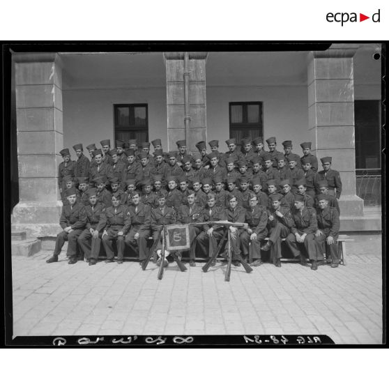 Photographie d'un groupe de militaires devant un fanion.