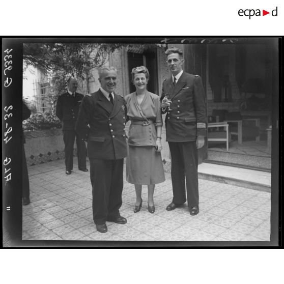 Deux officiers de la Marine et une femme lors d'une réception à Alger.