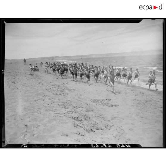 Les jeunes stagiaires courent sur une plage, lors d'un stage du service militaire préparatoire.