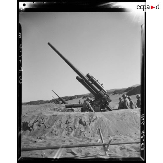 Essais de tirs d'artillerie sur une plage en Algérie.