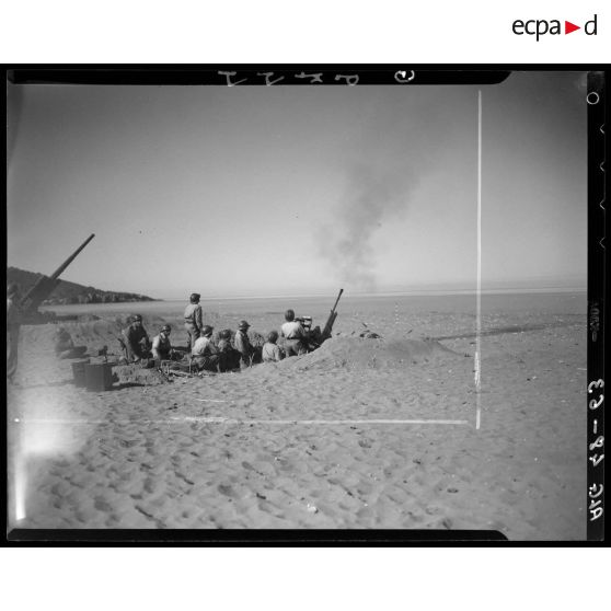 Essais de tirs d'artillerie sur une plage en Algérie.