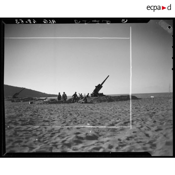 Essais de tirs d'artillerie sur une plage en Algérie.