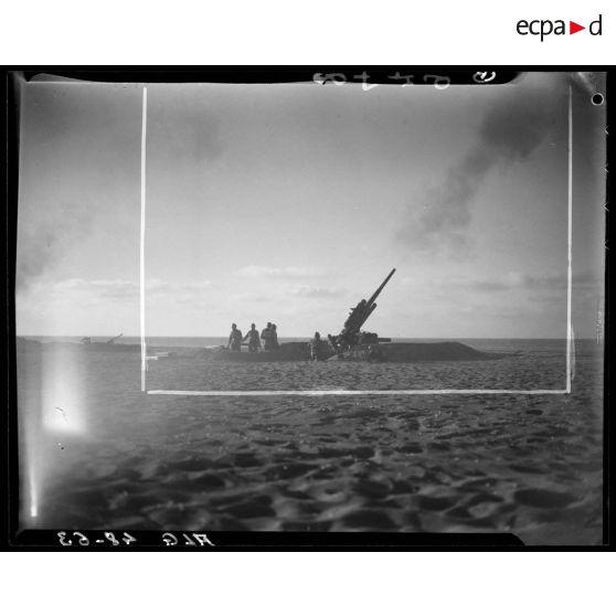 Essais de tirs d'artillerie sur une plage en Algérie.