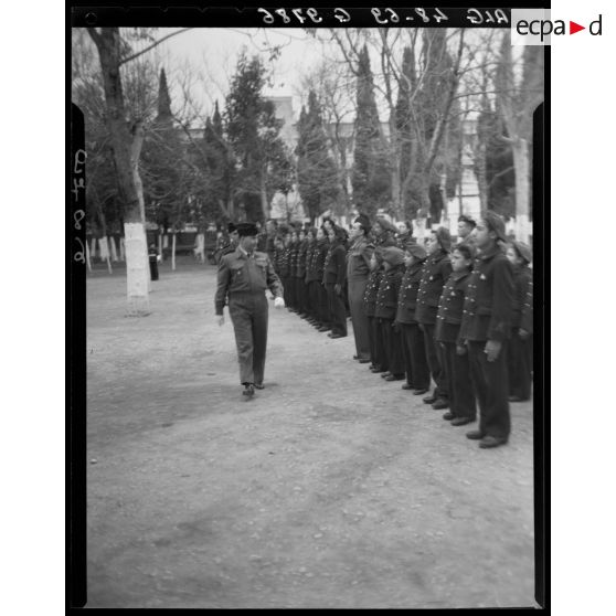 Un officier passe en revue des enfants de troupe, en Algérie, lors d'une cérémonie de Noël.