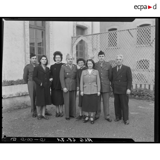 Portrait de groupe : trois militaires, quatre femmes et un homme en civil.