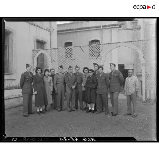 Portrait de groupe : des militaires, des femmes et deux hommes en civil.