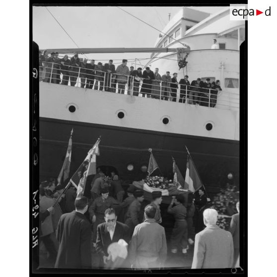 Les cercueils des militaires tombés en Afrique française du nord (AFN), sont hissés à bord du navire qui doit les rapatrier en métropole, sur le port d'Alger.
