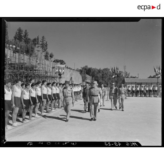 Des autorités militaires passent en revue des troupes de jeunes diplômés de la préparation militaire.