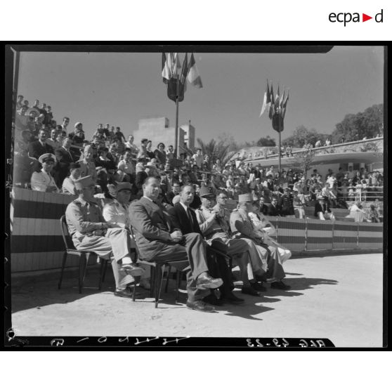 Plan large de la tribune depuis laquelle des autorités civiles et militaires assistent à la céremonie organisée à l'occasion de la fête de la préparation militaire.
