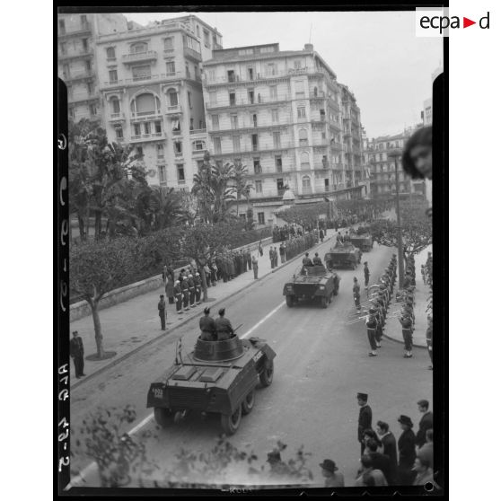 Une unité motorisée défile dans les rues d'Alger devant les autorités militaires.