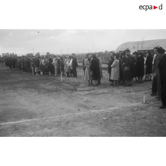 La foule qui assiste à une cérémonie militaire sur un terrain d'aviation en Algérie.