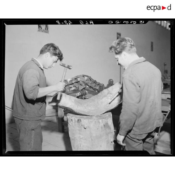 Deux élèves de l'Ecole de l'Air de Cap Matifou, s'exercent à travailler sur une pièce d'avion, dans un atelier.