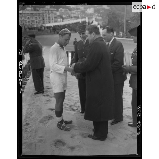 Une autorité civile remet une coupe à l'un des participants des championnats militaires interarmes d'Alger.