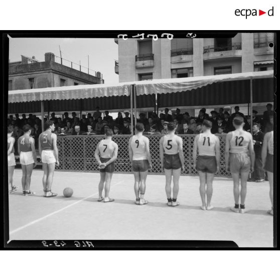 Présentation des équipes de volley-ball devant la tribune des officiels lors des championnats militaires interarmes d'Alger.