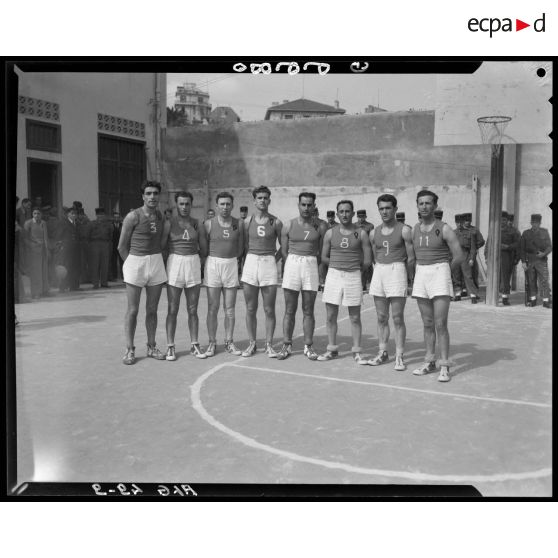 Une équipe de basket-ball pose devant le panier lors des championnats militaires interarmes d'Alger.