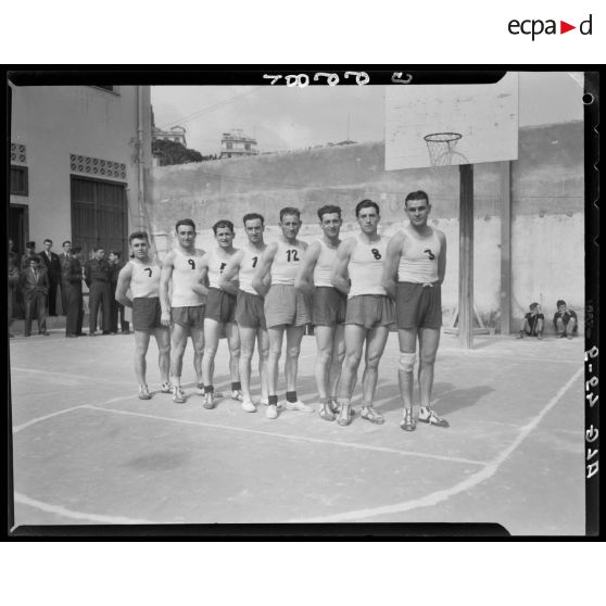 Une équipe de basket-ball pose devant le panier lors des championnats militaires interarmes d'Alger.