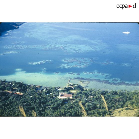 Les Gambiers, cocotiers, mer, corail, cathédrale en rouge, bâtiment du S.M.C.B. [légende d'origine]