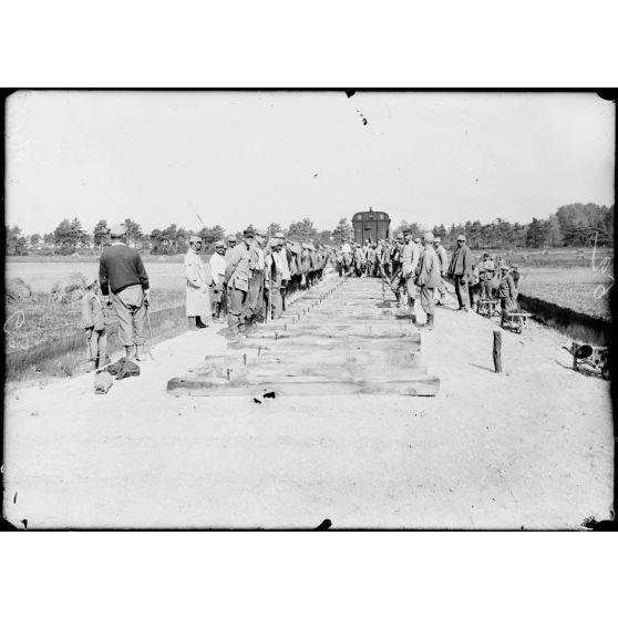Près de Châlons-sur-Marne. Construction d'une voie ferrée du camp de Mailly à Saint-Hilaire-le-Grand. Pose des traverses amenées par le train. [légende d'origine]