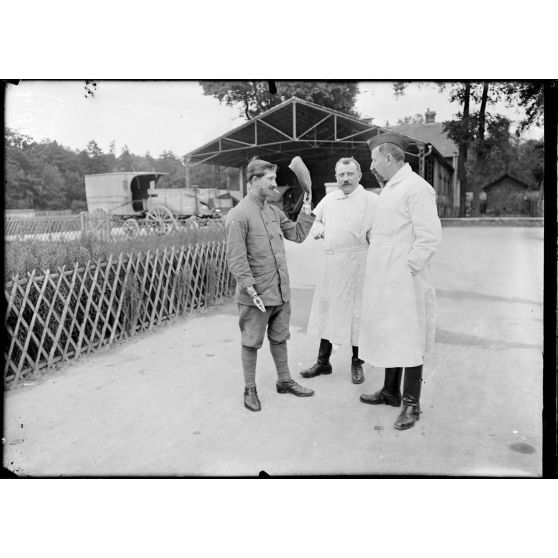 Saint-Maurice (Seine). Hôpital militaire n°5 bis. Soldat Robin sortant de l'hôpital et saluant (avec sa main artificielle) des majors. [légende d'origine]