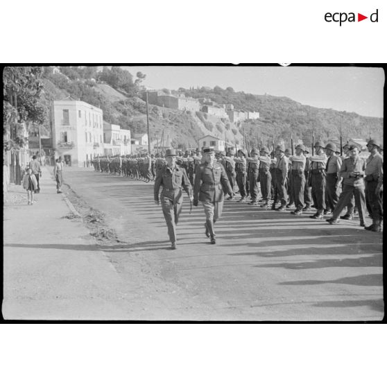 Deux autorités militaires passent en revue les troupes de l'armée d'Afrique.