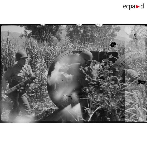 Deux soldats tirent à l'obusier, canon régimentaire de 76 mm M1927.