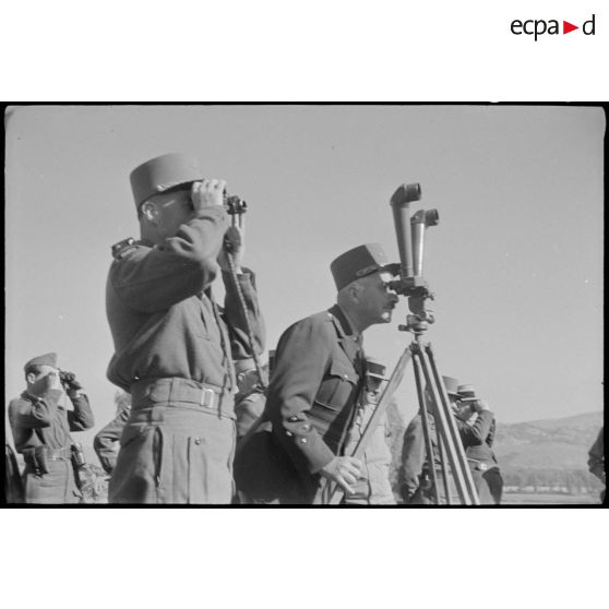 Deux généraux étudient le terrain à l'aide d'un télémètre, pour observer le déroulement de la manoeuvre.