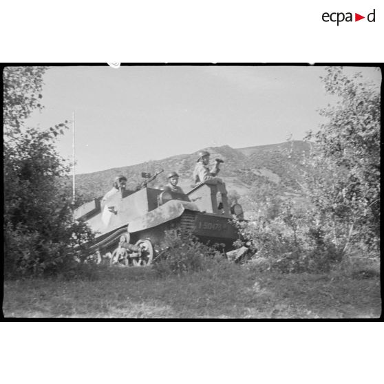 Un Bren Carrier, blindé de reconnaissance, effectue une mission, trois soldats à son bord.