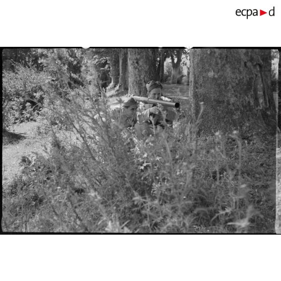 Deux soldats s'entrainent au tir avec un bazooka, dans la forêt.