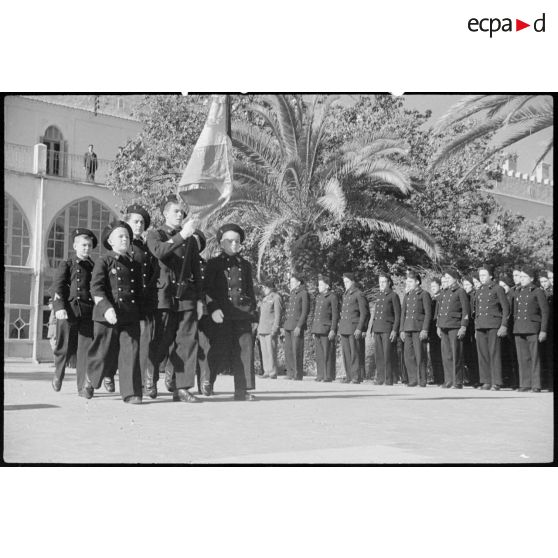 Les élèves de l'école militaire préparatoire nord-africaine (EMPNA) d'Hamman Righa défilent avec le drapeau de l'école.