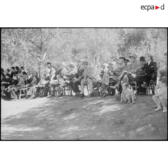 Photographie de groupe rassemblant le général de corps d'armée Henry Martin, commandant le 19e corps d'armée (CA), et des personnalités militaires et civils, assis en plein air, qui assistent à la fête annuelle de l'école militaire préparatoire nord-africaine (CA) d'Hammam Righa.