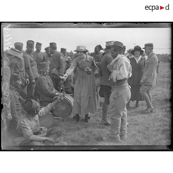 Vouzy. Marne. Fête de la Division Marocaine. Les artistes du théâtre aux armées offrant des cigarettes aux soldats. [légende d'origine]