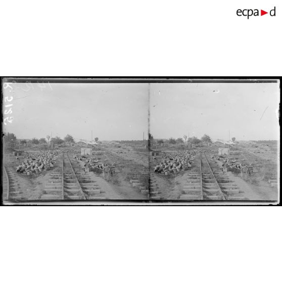 Ham (Somme). Zinc ramassé par les allemands et qu'ils n'ont pu emporter, au fond, la gare achevant de brûler. [légende d'origine]