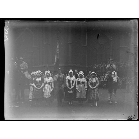 Strasbourg. Voyage de Mr Poincaré. Le porte-drapeau d'un régiment au milieu de jeunes Lorraines. [légende d'origine]