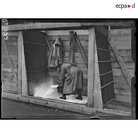 Fesches-la-Chapelle, Haut Rhin. Recommandations en cas d'alertes à gaz. Un homme doit aussitôt arroser l'entrée de l'abri. [légende d'origine]