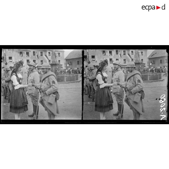 Massevaux. Alsace. Fête anniversaire de l'entrée des Français. Jeune alsacienne offrant des fleurs à des soldats. [légende d'origine]